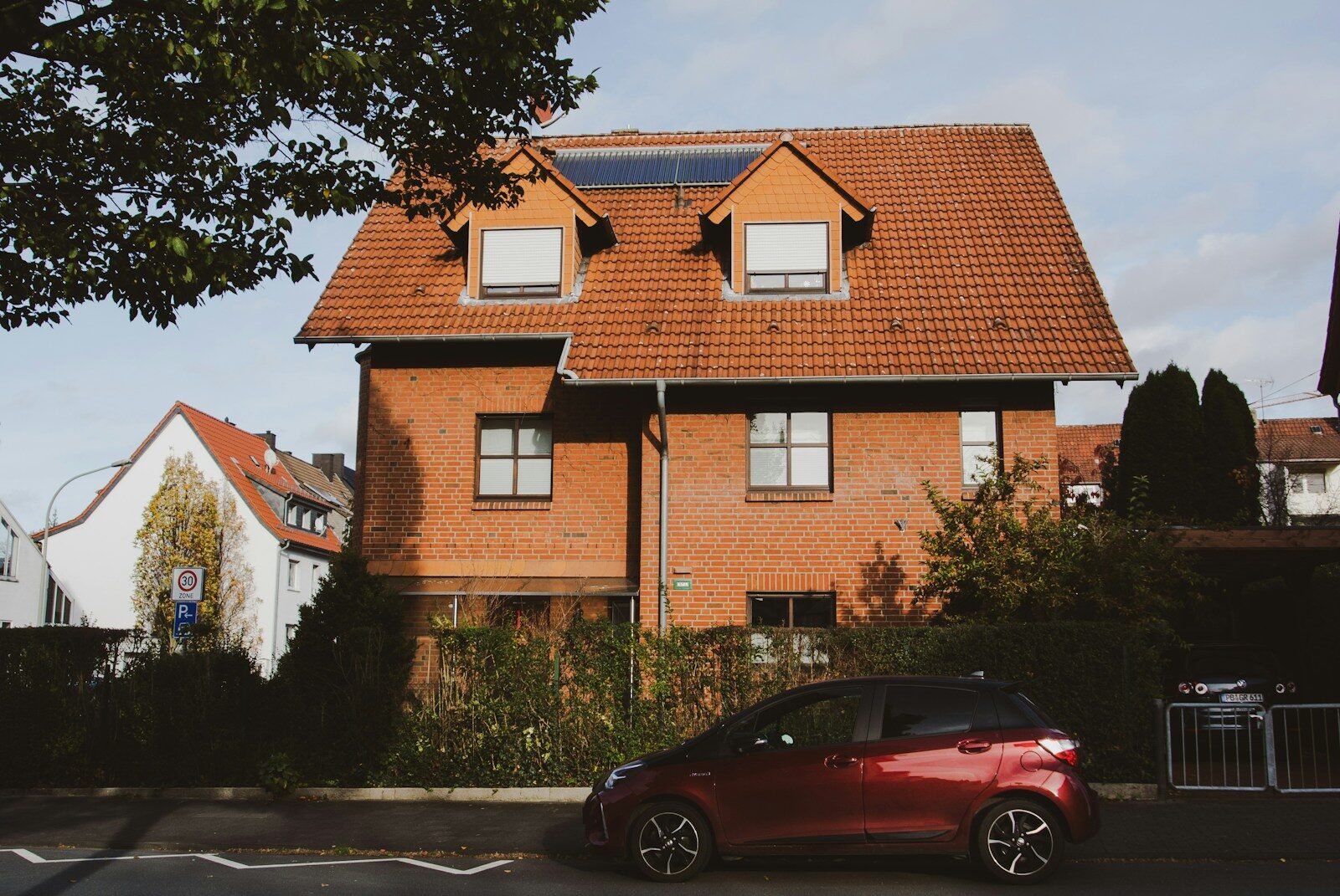 a red car parked in front of a house